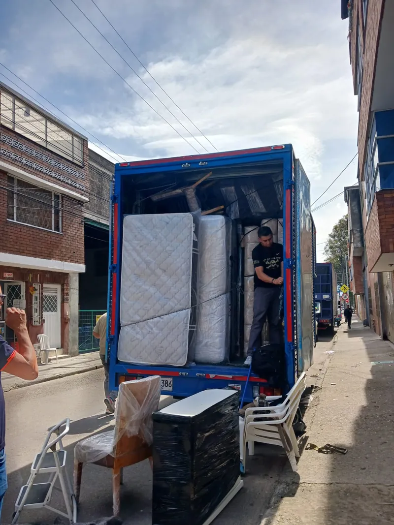 Equipo cargando muebles al furgón en la calle